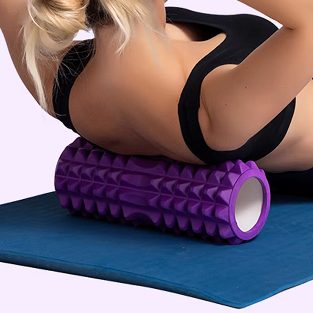 Yoga practitioner using a foam roller to enhance flexibility and muscle recovery in a serene studio setting